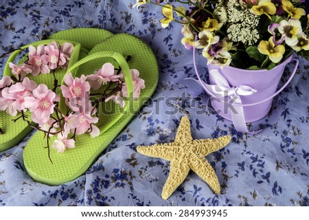 summer scene with flip flops purple pale star fish and flowers on vintage blue dress