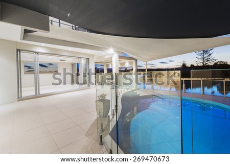 White modern luxurious mansion exterior with deck and swimming pool on the Gold Coast, Queensland Australia