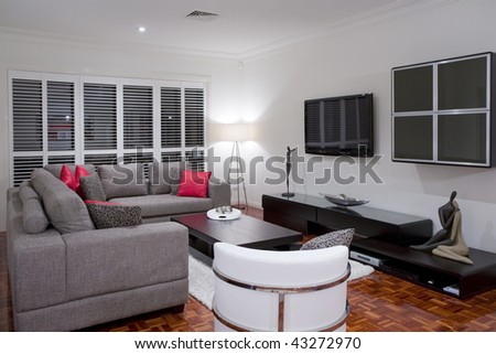 modern living room interior with charcoal sofa and chocolate brown coffee table and wide screen plasma TV.