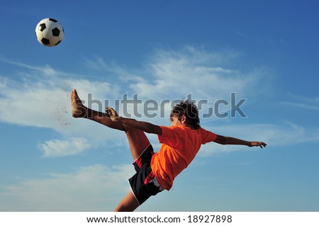 Young boy playing football - low angle view