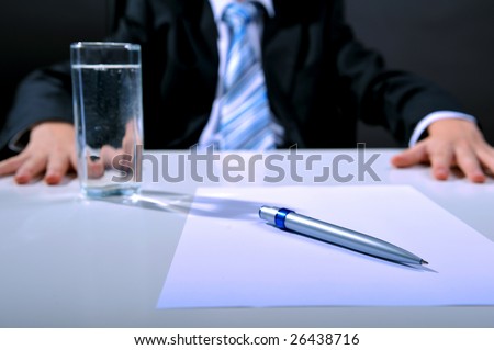 Desk detail with blank paper a pen and businessman hands