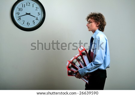 Young businessman holding stack of folders in office, deadline concept