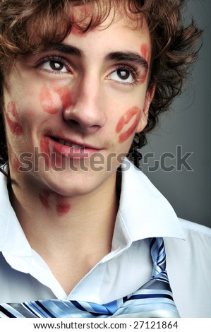 Portrait of young businessman covered in lipstick kisses