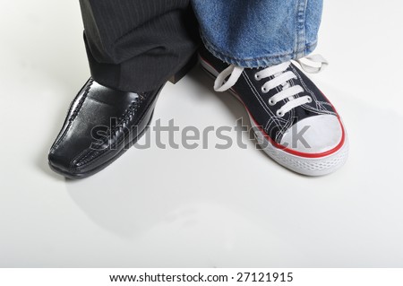 Mans legs wearing jeans and sneaker on a leg and suit on other