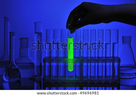 Hand take test tube with luminosity liquid from support