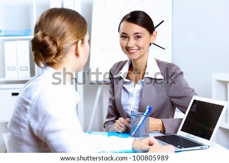 Young women in business wear working in office together