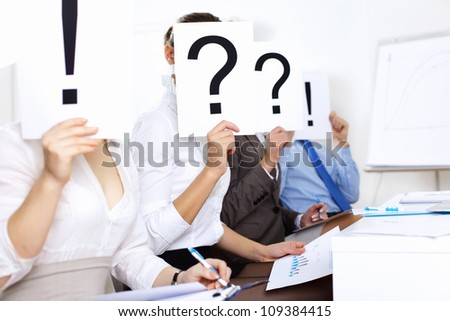 Image of businessmen in office with question marks