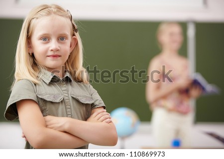 Little blonde girl studying at school class