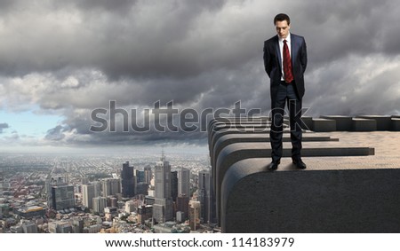 Business man standing high over a cityscape