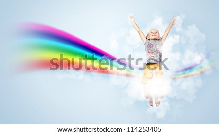 Photo of little girl jumping and raising hands against rainbow background