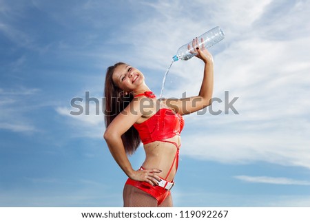 Young female sport girl in red uniform with a bottle of water