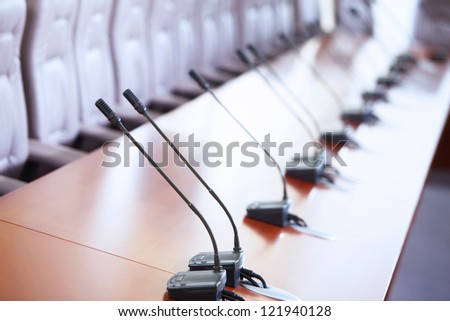 before a conference, the microphones in front of empty chairs.