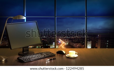 Work place in the office at night with a city view from window