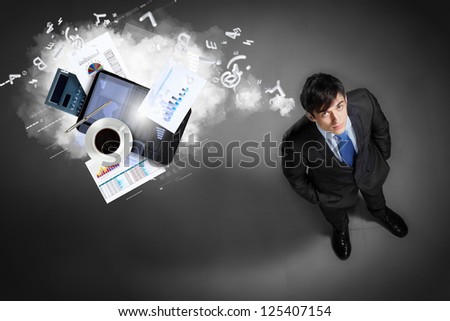 Image of business objects flying in air top view against businessman background