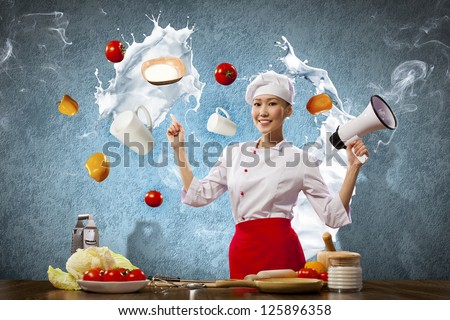 Asian female cook holding megaphone vegetables flying in air