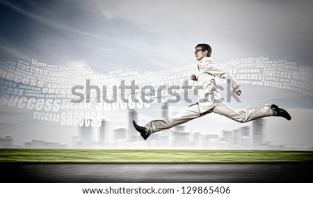 Young businessman in suit running on the road