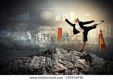 young businesswoman standing on one leg atop of mountain against diagram background