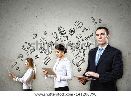 Three young people in business suits with tablet pc in hands