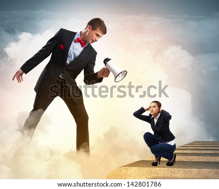 Angry businessman with megaphone shouting at colleague