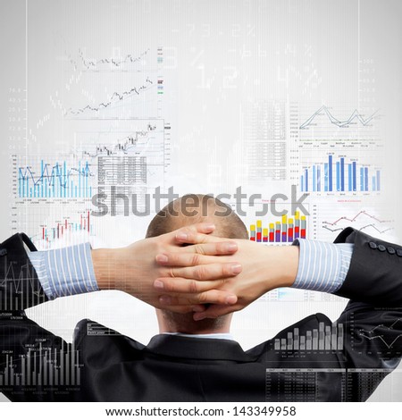 Back view image of businessman with arms crossed behind head