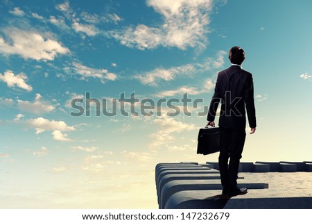 Image of young businessman standing on top of building