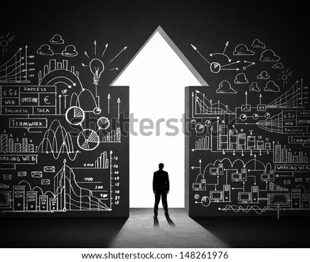 Silhouette of businessman against black wall. Business direction