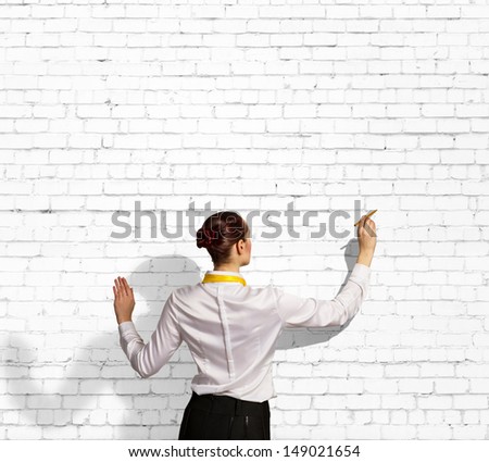 Businesswoman standing with back drawing on blank wall
