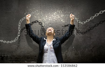 Image of businesswoman in anger breaking metal chain