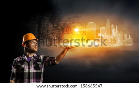 Image of man builder touching icon of media screen