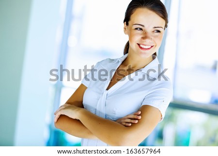 Image of young attractive businesswoman with arms crossed on chest