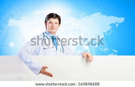 Image of handsome doctor holding white blank banner