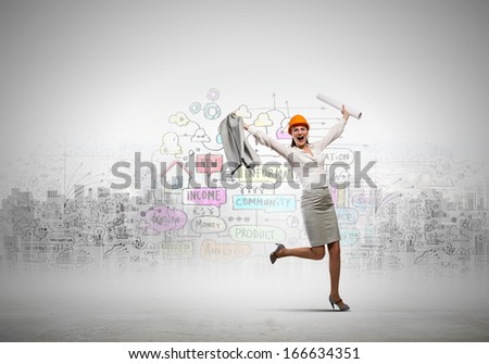 Young woman engineer in helmet jumping joyfully