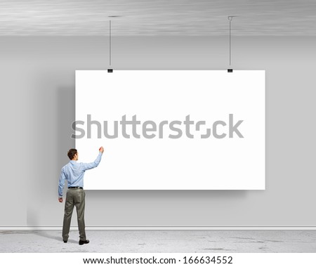 Image of businessman standing with back and writing on blank banner