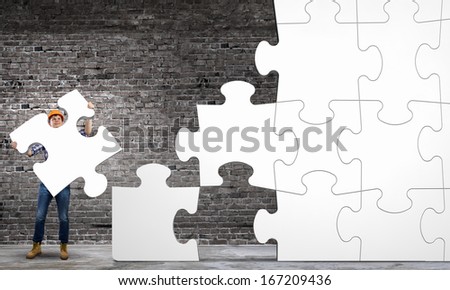 Image of man engineer connecting puzzle elements. Construction concept