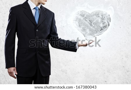 Businessman holding stone in shape of heart in palm
