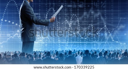 Back view of businessman speaker standing on podium with papers in hand