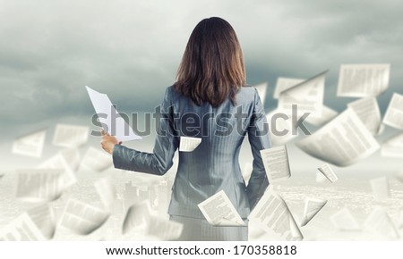 Back view of businesswoman holding papers in hands