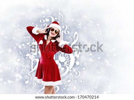 Young attractive Santa girl listening music in headphones