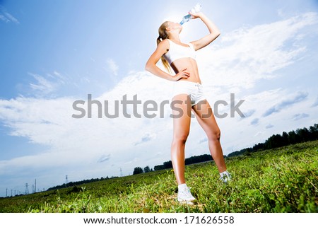 Young beautiful girl training outdoor in summer