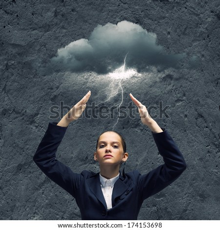 Young crying businesswoman with arms covering head from rain