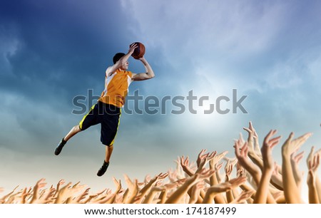Young man throwing ball into basket in jump