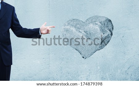 Businessman pointing at stone in shape of heart