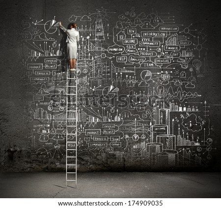 Rear view of businesswoman standing on ladder and drawing business sketch on wall