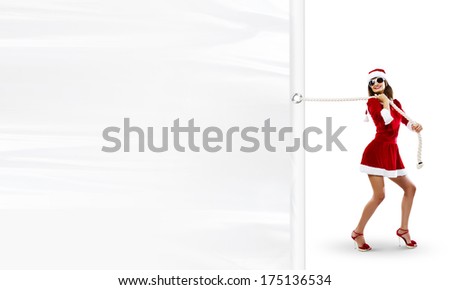 Girl in Santa costume pulling white blank banner. Place for text