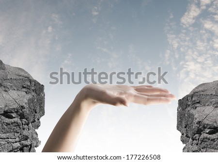 Close up of human hand between mountain gap