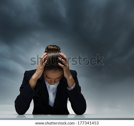 Young crying businesswoman with hands on head
