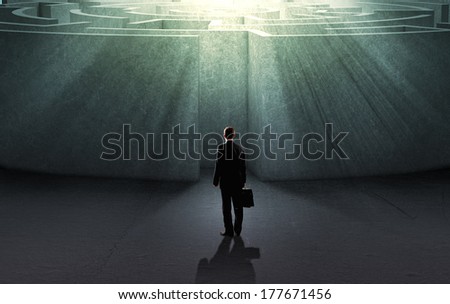 Successful businessman standing near the entrance of labyrinth