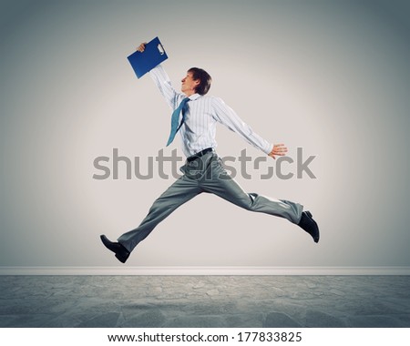 Young businessman in jump against blank background