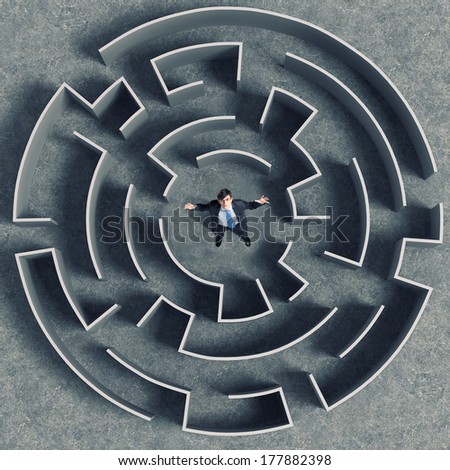 Top view of successful businessman standing in center of labyrinth