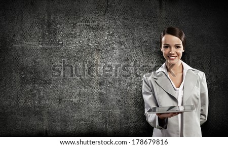 Woman with tablet pc against dark background